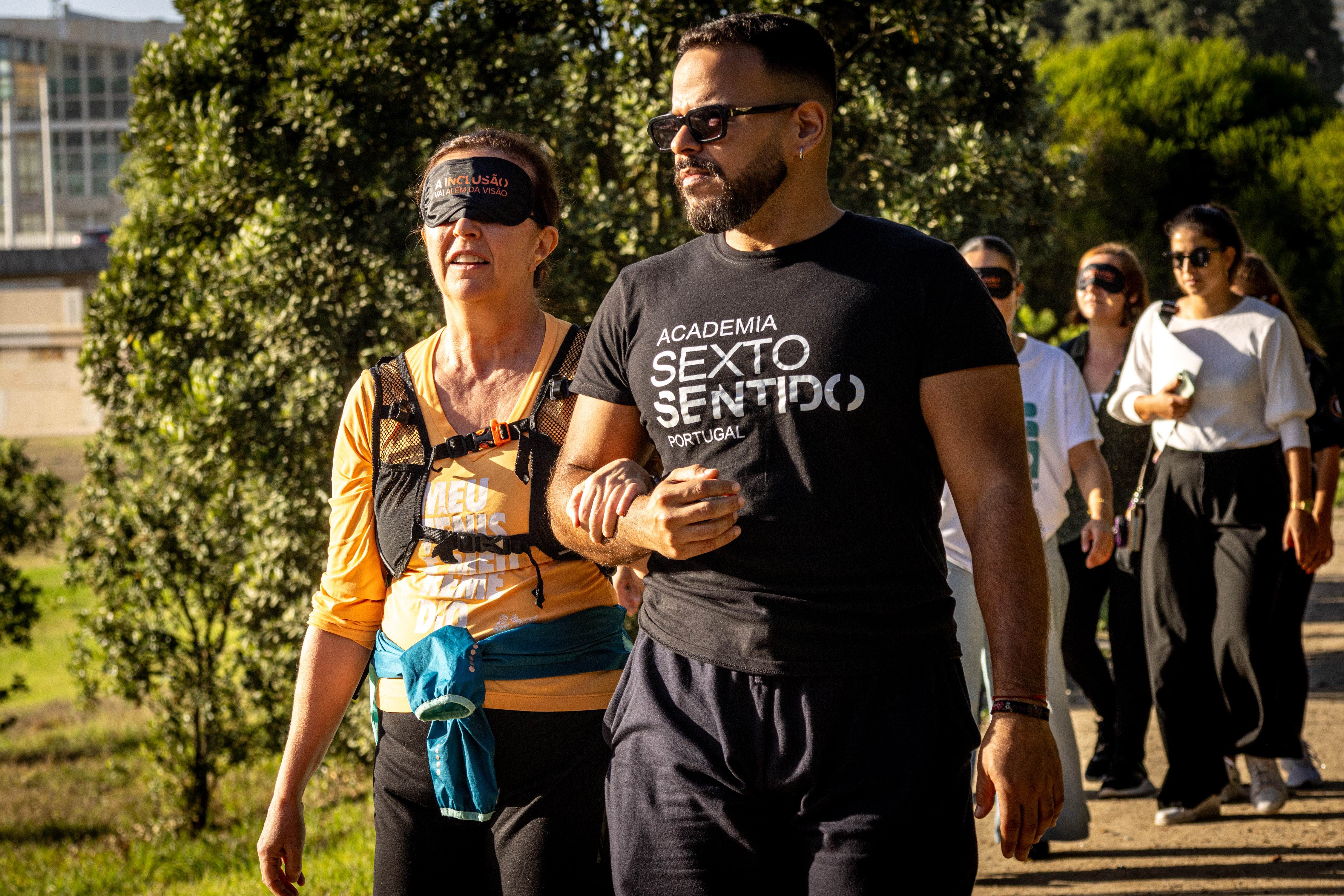 Atleta e guia de braço cruzado durante um percurso